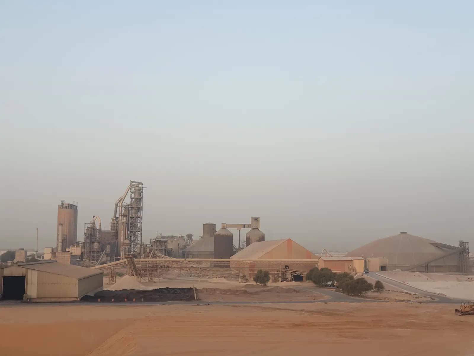 Industrial factory buildings in a desert landscape under a clear sky